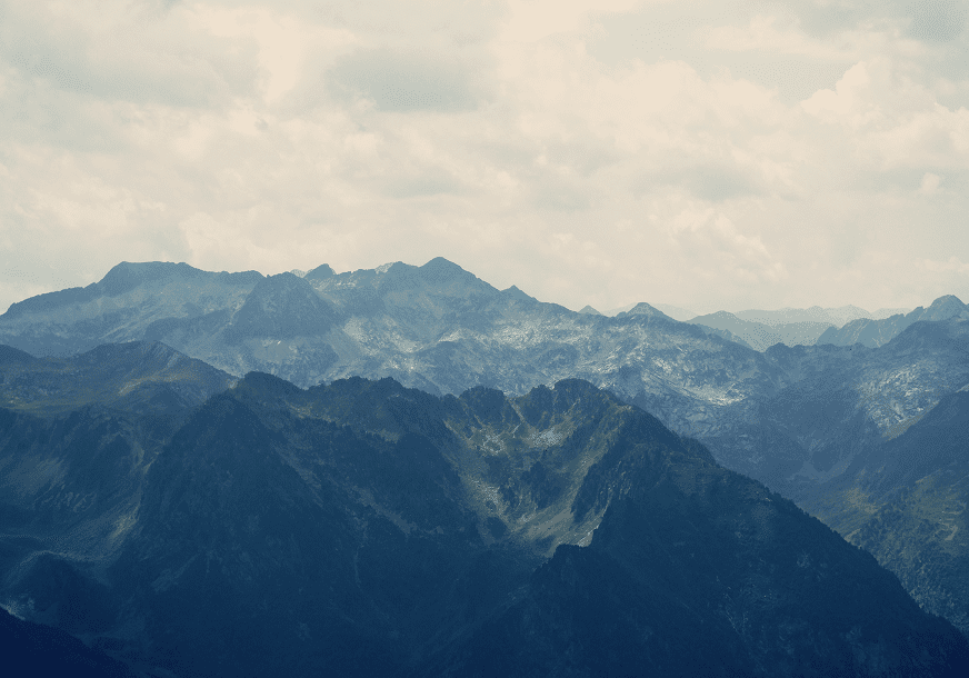 Mountain range under cloudy sky.